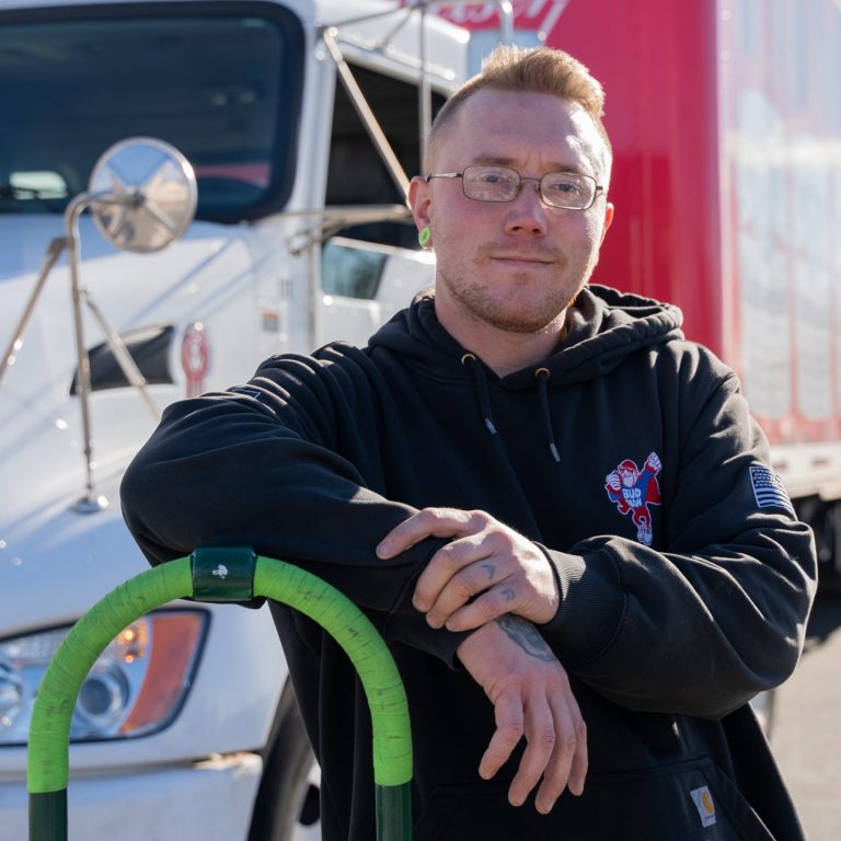 driver posing in front of delivery truck